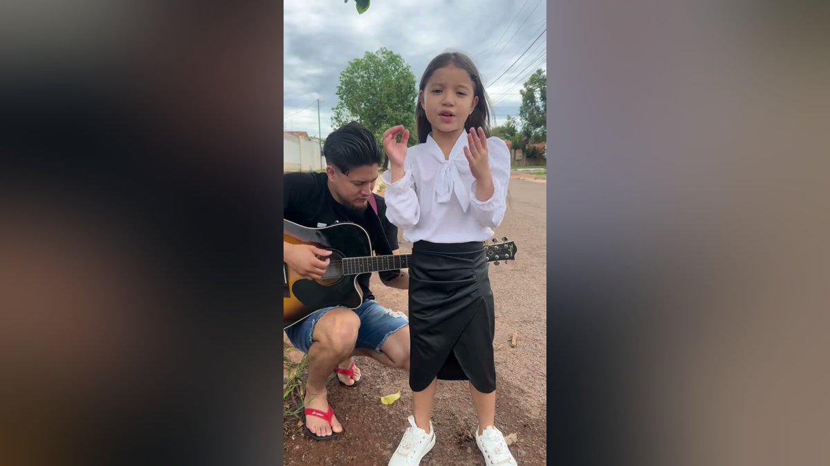 Menina louva a Deus na rua ao som de violão e emociona com canção de fé